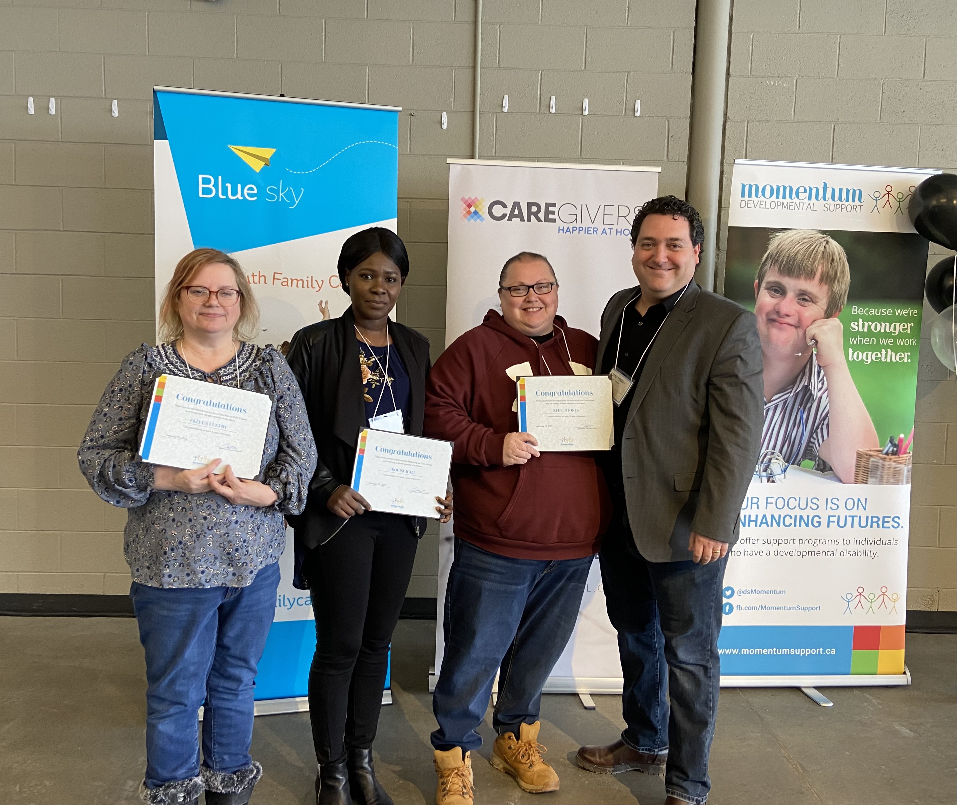 Our Executive Director, Chad standing with 3 employees who received their years of service certificates.